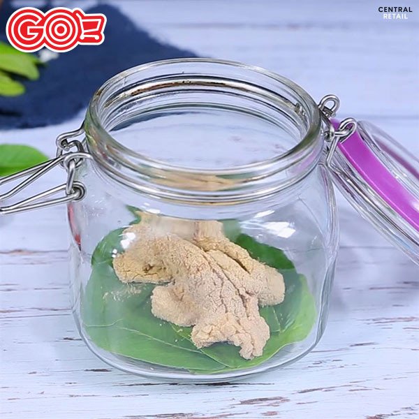 Hũ thủy tinh chứa thịt chua Thanh Hóa đang được ủ cùng lá ổi, lá sung, lá đinh lăng.