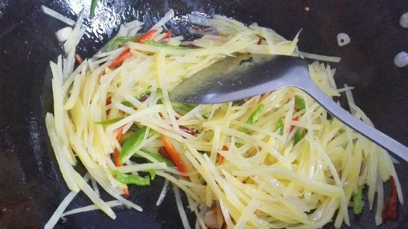 Khoai tây đang được xào trên chảo nóng