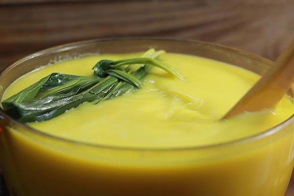 Khuấy đều hỗn hợp sữa và bí đỏ để hoàn thành cách nấu sữa bí đỏ