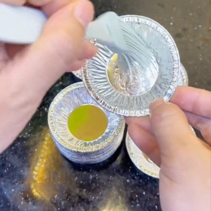 Khuôn giấy bạc được thoa bơ chuẩn bị cho món bánh phô mai dẻo