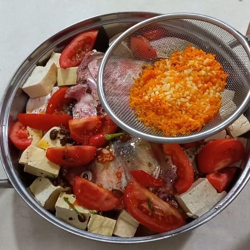 Lọc lấy nước mẻ đã trộn với nghệ để tạo hương vị đặc trưng cho món cá mè nấu mẻ