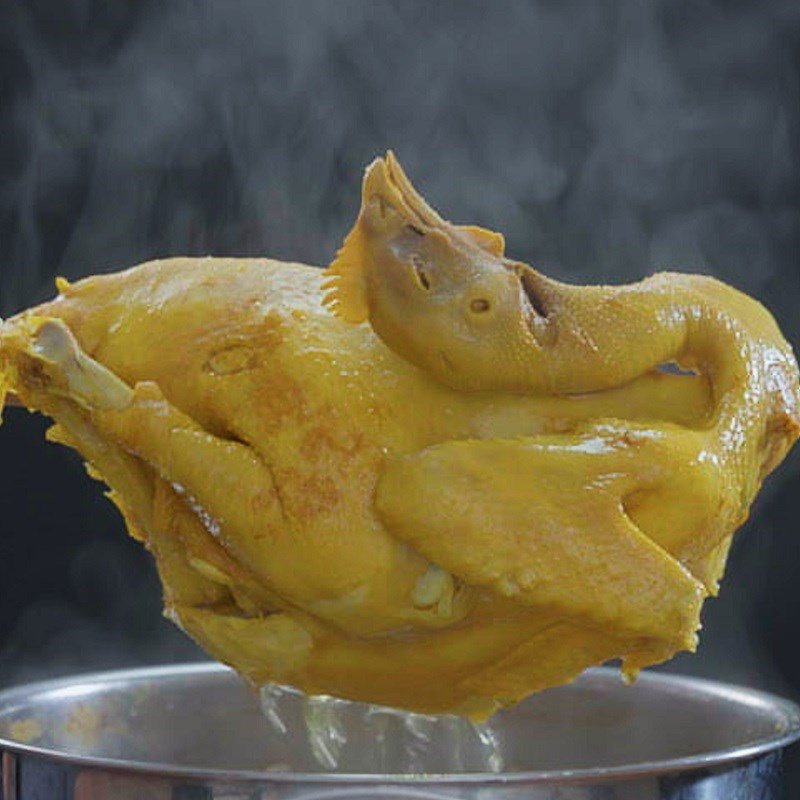 Luộc gà nguyên con với gừng, hành tím và bột nghệ để có màu vàng đẹp