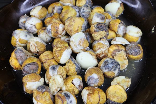 Luộc và bóc vỏ trứng cút lộn cẩn thận, giữ lại nước bên trong để món xào me thêm đậm đà.