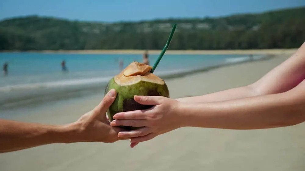 Ly nước dừa xiêm mát lạnh kèm lát chanh, biểu tượng cho thức uống ít calo từ dừa xiêm không gây tăng cân và phù hợp cho người ăn kiêng.