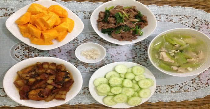 Mâm cơm gia đình với cá kho thịt, bò xào cần tỏi, canh bí xanh nấu thịt