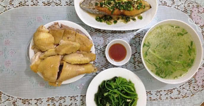 Mâm cơm gia đình với gà luộc, cá thu rim mắm tỏi