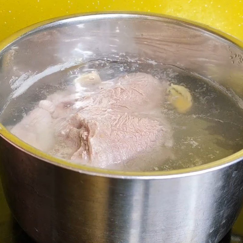 Miếng thịt lợn sau khi luộc đang được vớt ra để nguội