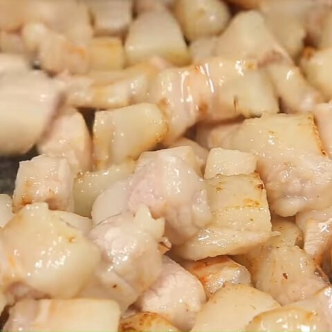 Mỡ heo đang được cắt hạt lựu và thắng trên chảo để lấy tóp mỡ và nước mỡ cho món thịt chưng mắm ruốc