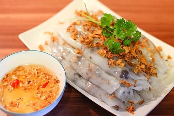 Món bánh cuốn truyền thống thơm ngon, trang trí đẹp mắt với chả lụa và rau sống, thể hiện sự hấp dẫn của ẩm thực Việt.