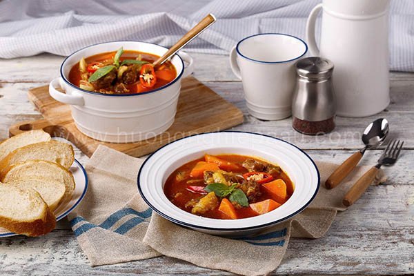 Món bò kho thơm ngon nóng hổi được phục vụ kèm bánh mì giòn tan và rau thơm.