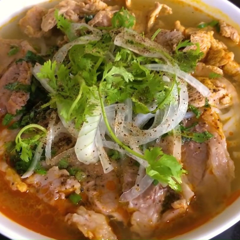 Món bún bò tái với thịt bò tươi và nước dùng đậm đà