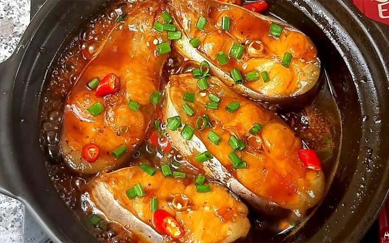 Món cá ba sa kho tộ nóng hổi với màu cánh gián đẹp mắt, rắc hành lá và ớt tươi