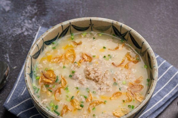 Món cháo bí đỏ đậu xanh thịt băm rắc hành lá, tiêu