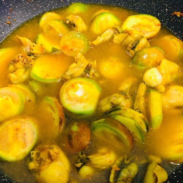 Món ếch om cà đậu phụ đang được đun sôi nhẹ trên bếp