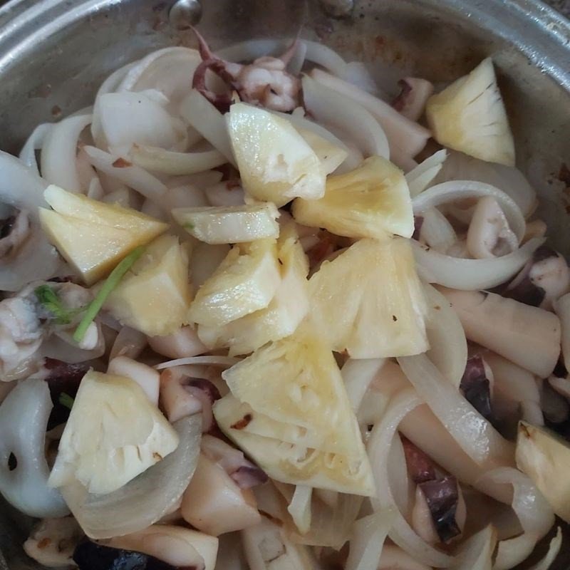Món mực nang xào dứa hành tây đang được hoàn thành trên chảo