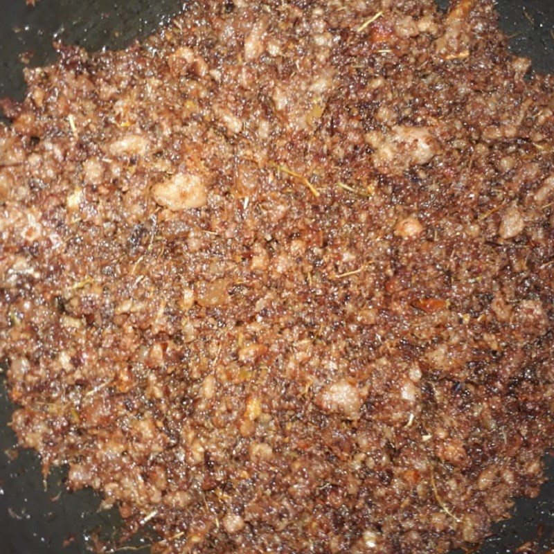 Món thịt chưng mắm ruốc đang được đảo đều trên chảo với lửa nhỏ, nước sốt sánh mịn và thơm lừng