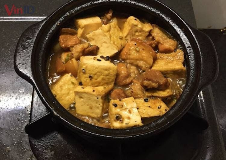 Món thịt kho đậu hũ đang được nấu trên bếp lửa