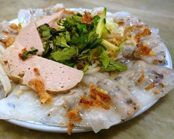 Một đĩa bánh cuốn đầy đặn với nhân thịt và các loại topping, gợi lên câu hỏi về lượng calo tổng thể của món ăn.