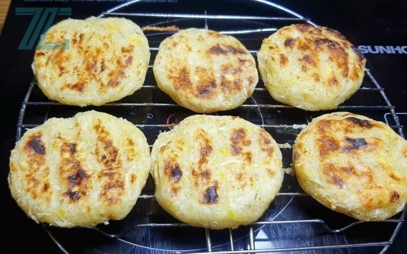 Một miếng bánh sắn nướng đang được cầm, đặt câu hỏi về việc ăn bánh sắn nướng có bị mập không