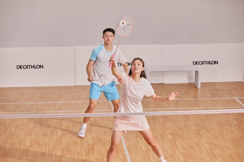 Một người chơi cầu lông đang chọn vợt và giày thể thao trong cửa hàng