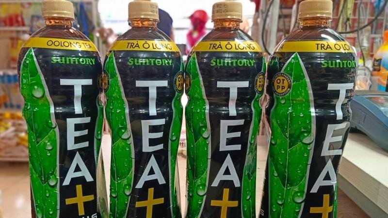 Một người đang cầm chai trà ô long Tea Plus, tượng trưng cho việc sử dụng sản phẩm này như một phần của chế độ ăn kiêng và giảm cân