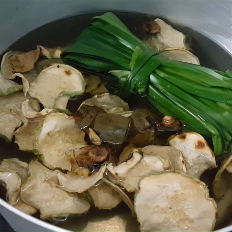 Một nồi trà bí đao đang sôi nhẹ trên bếp, với lá dứa và la hán quả, minh họa cách nấu trà bí đao hạt chia.