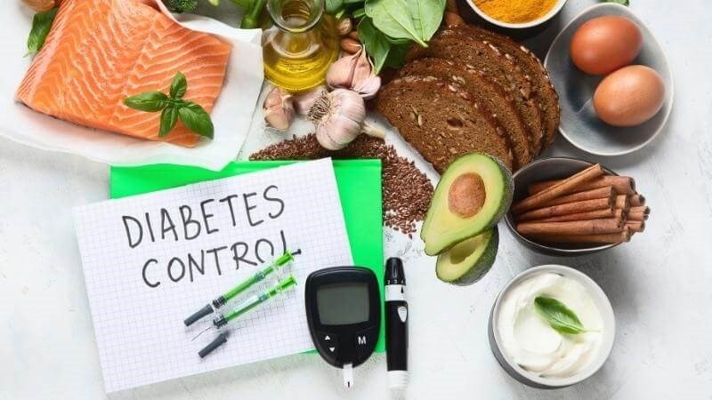 Một nửa quả bơ sáp cắt lát đặt cạnh dụng cụ kiểm tra đường huyết, thể hiện lợi ích cho người tiểu đường