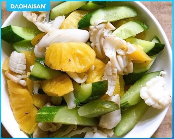 Mực đang được xào cùng dưa leo và cà chua trên chảo nóng