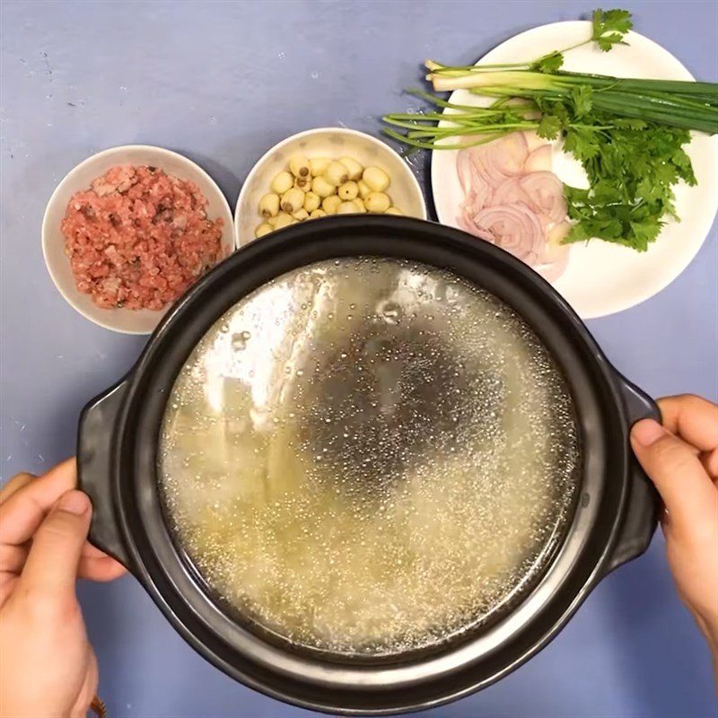 Nấu sôi gạo và đậu xanh trong nồi, chuẩn bị cho quá trình nấu cháo bồ câu