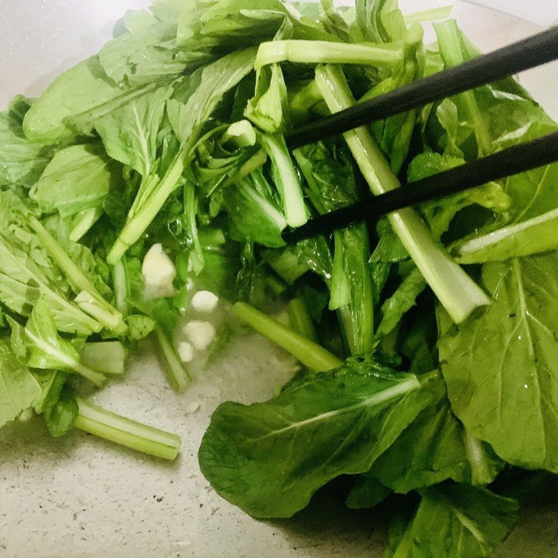 Nêm dầu hào vào cải ngọt đang xào