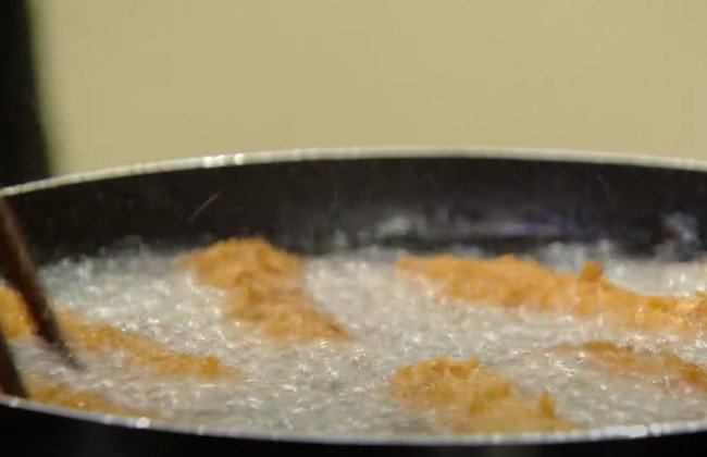 Nem thịt rán đang được chiên vàng trên chảo dầu