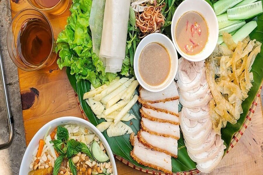 Người đang thưởng thức bánh tráng cuốn thịt heo trong bữa ăn