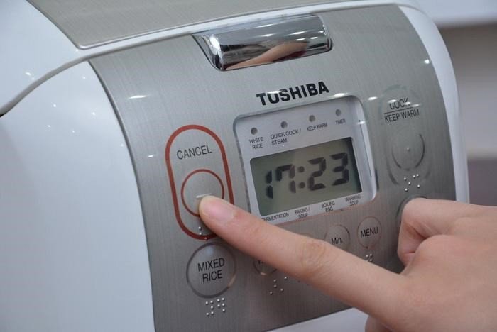 Người dùng đang xới cơm từ nồi cơm Toshiba