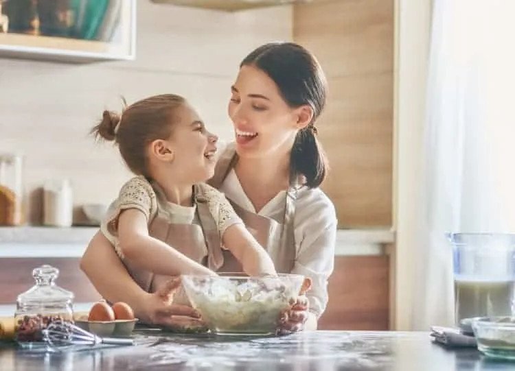 Người lớn đang hướng dẫn trẻ ăn cháo yến mạch một cách an toàn