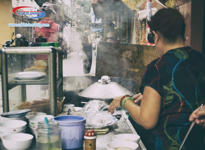 Người phụ nữ đang lựa chọn hạt gạo để chuẩn bị cho cách pha bột bánh cuốn truyền thống.