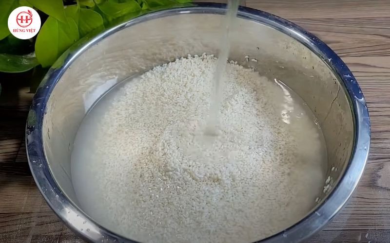 Người phụ nữ đang vo gạo nếp, bước đầu tiên để có xôi dẻo lâu