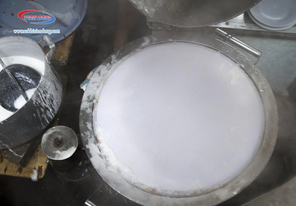 Người thợ đang tráng vỏ bánh cuốn mỏng đều trên nồi hơi, thể hiện kỹ thuật điêu luyện.