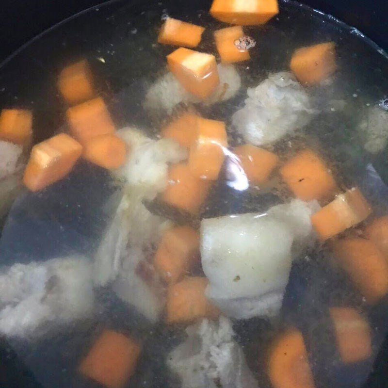 Nguyên liệu canh rau củ gồm xương heo và các loại củ đã được xào thơm, sẵn sàng cho nước vào