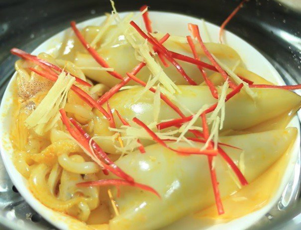 Những con mực nhồi thịt được xếp gọn gàng trong nồi hấp, tỏa hương thơm lừng