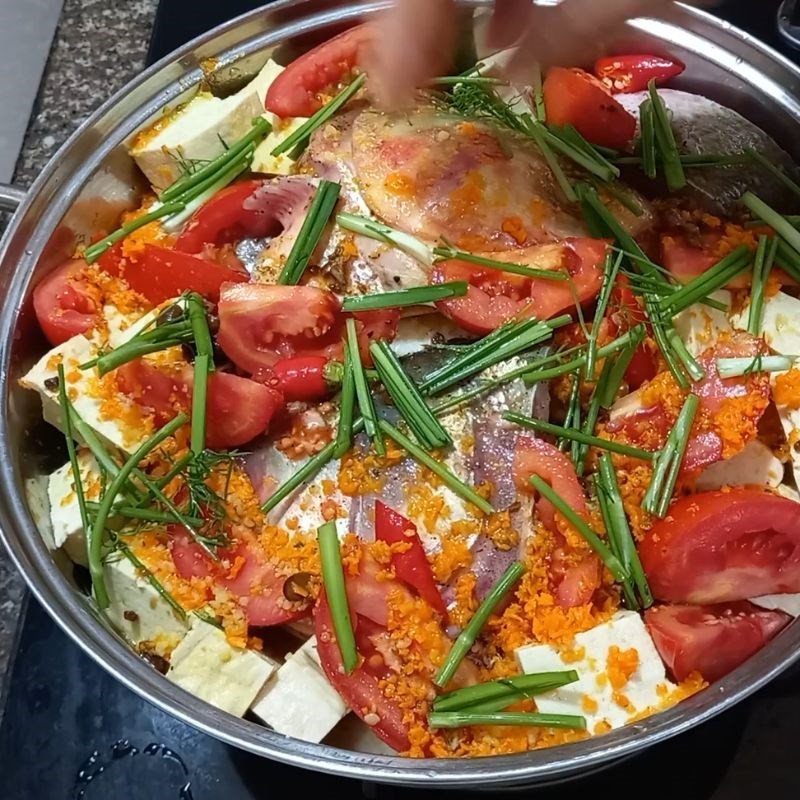 Nồi cá mè đã được ướp đều gia vị và thì là, chuẩn bị cho quá trình nấu