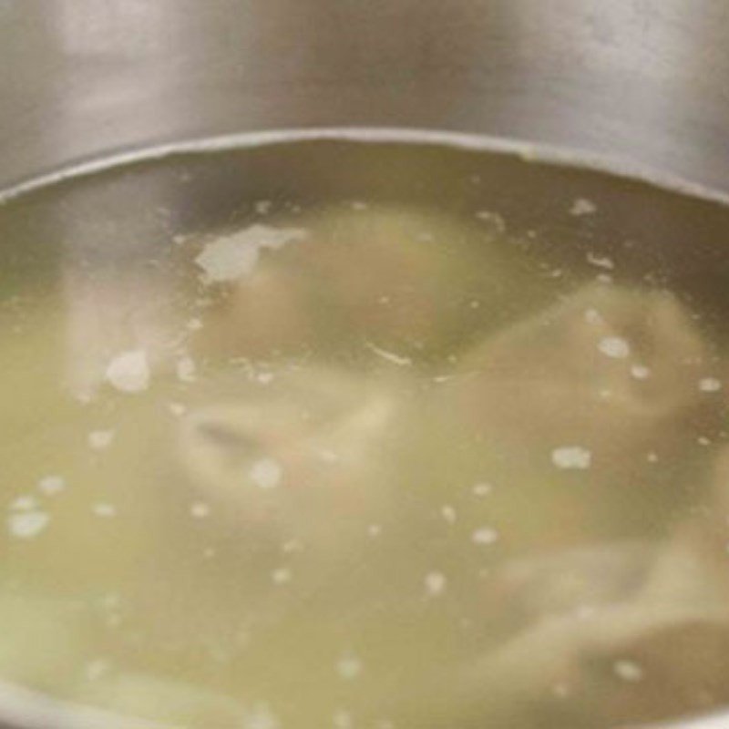 Nồi canh măng khô với xương đang sôi, nước dùng trong vắt