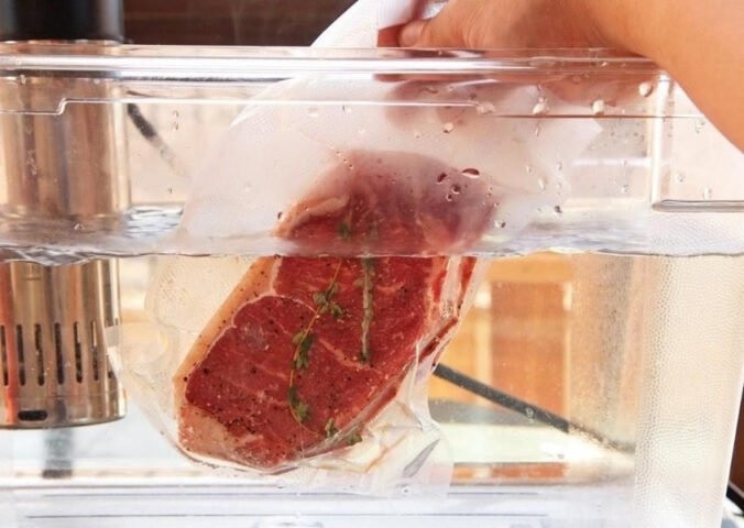 Nồi cháo ăn dặm đang nấu trên bếp, bên cạnh là chén cháo nhỏ và thìa, biểu tượng cho việc chuẩn bị bữa ăn cho bé 6 tháng.