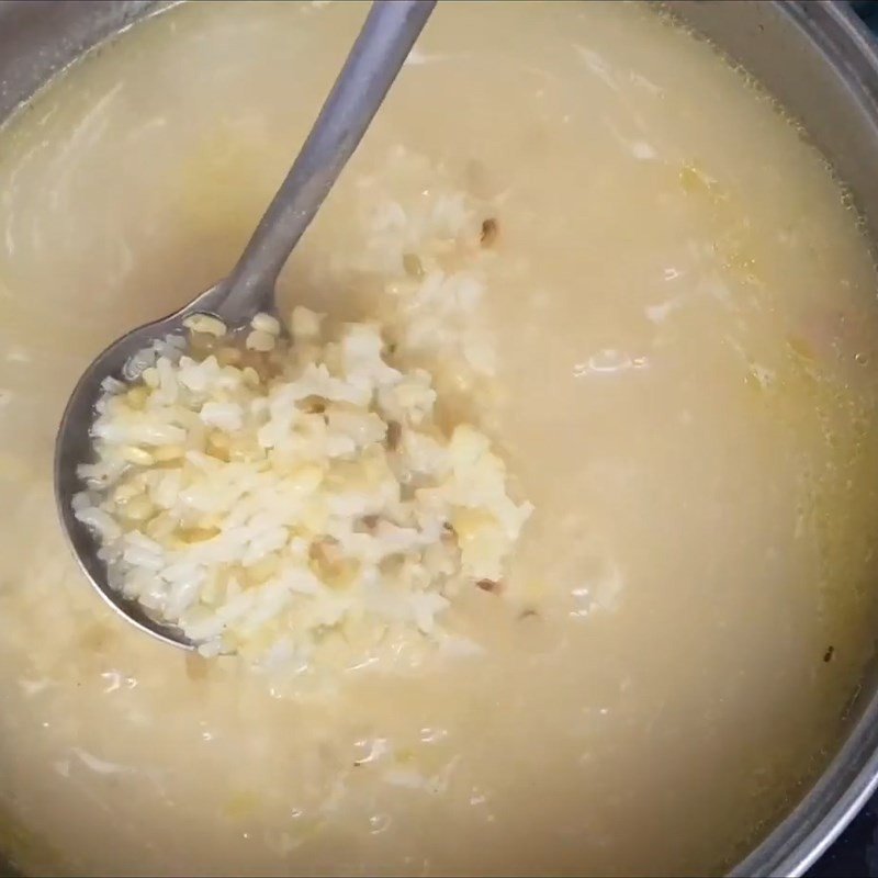 Nồi cháo gà đậu xanh đang sôi trên bếp, gạo và đậu xanh nở mềm