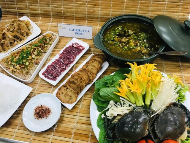 Nồi lẩu cua đồng thơm ngon, hấp dẫn với riêu cua nổi bật, rau xanh và bún tươi.