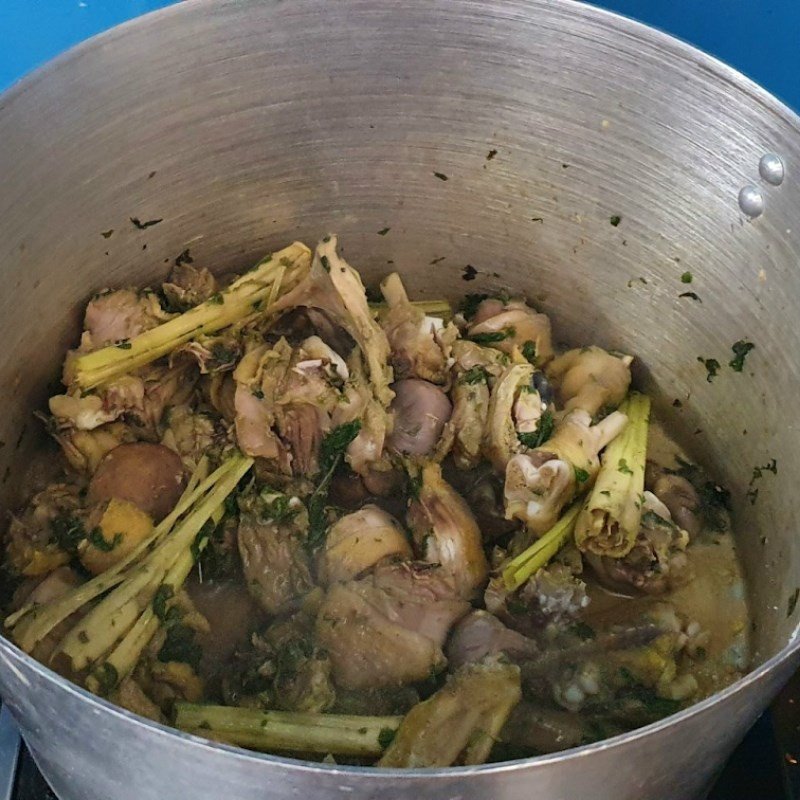 Nồi lẩu gà lá é đang sôi trên bếp, bốc khói nghi ngút