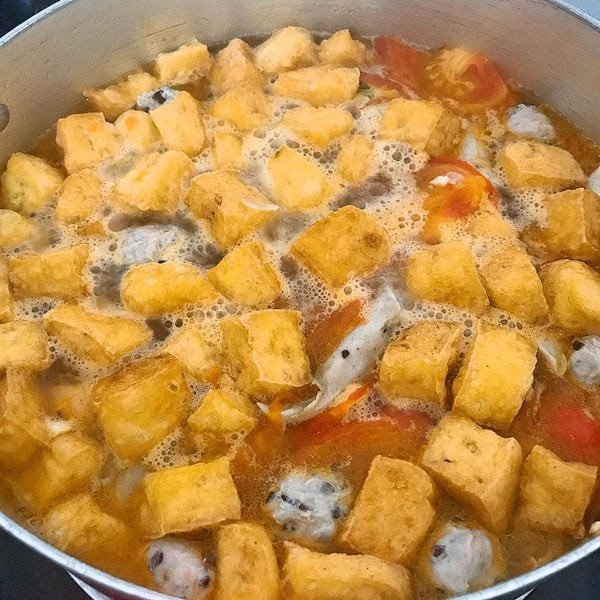 Nồi nước dùng bún ốc với cà chua và gia vị