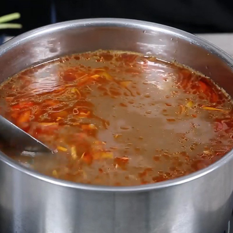 Nồi nước dùng đang sôi cho món canh tiết lợn
