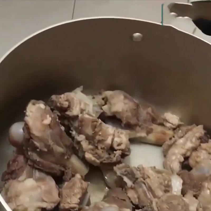Nồi xương heo đang được hầm, tạo nên nước dùng bánh canh xương heo thơm ngọt