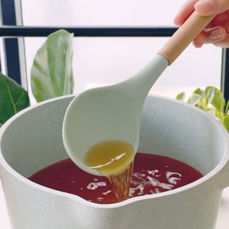 Nước chấm chua ngọt đang được đun sôi và khuấy đều trong nồi nhỏ