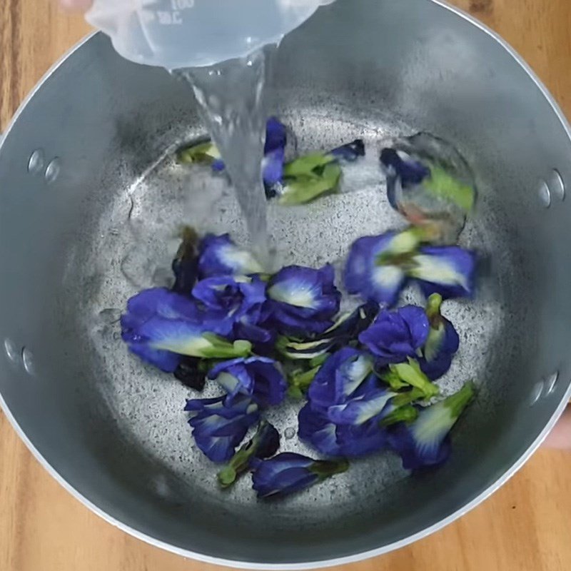 Nước hoa đậu biếc xanh biếc đang được đun để tạo màu cho xôi hoa đậu biếc